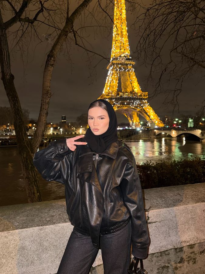 Kielo by the Eiffel Tower at night, in a black leather jacket